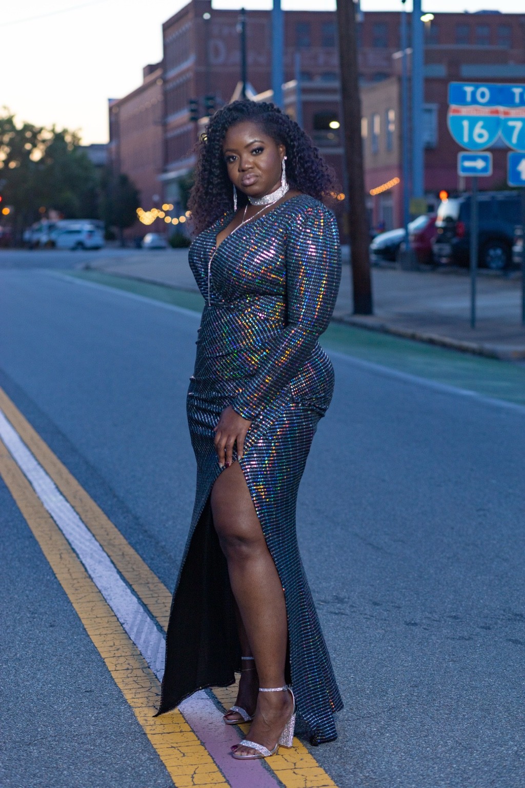 Shonte in a sparkling gown on a downtown street at dusk